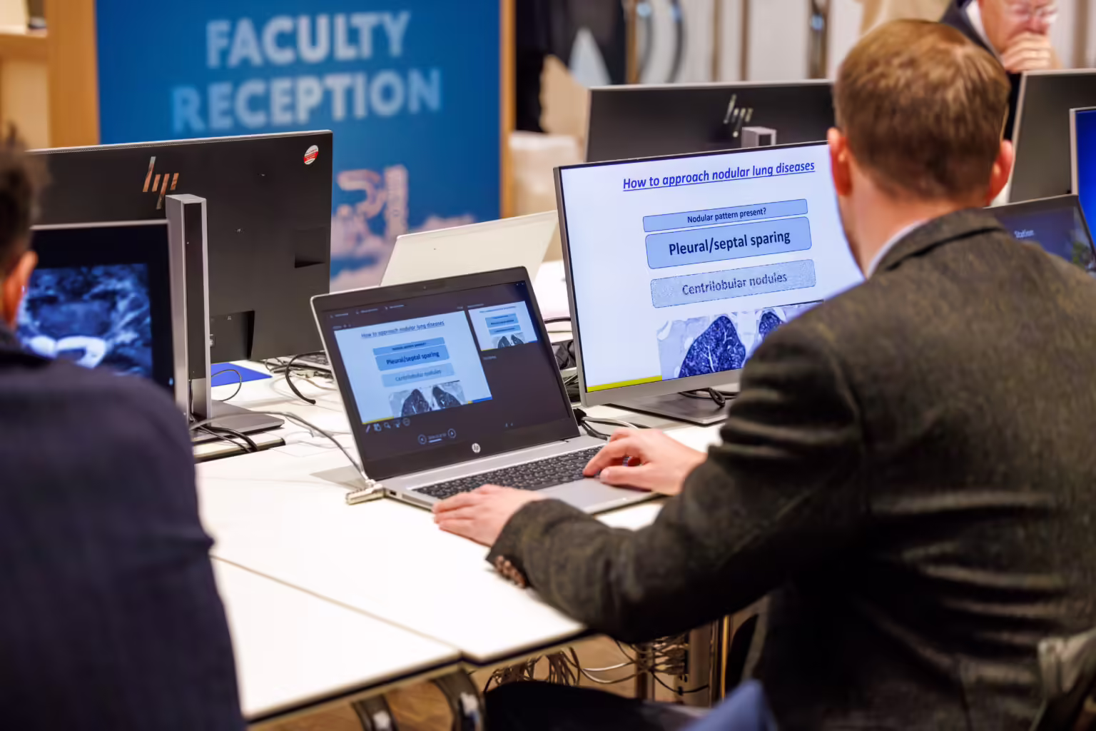 Conference presenter reviewing and testing their presentation file on a laptop at a Slidecrew speaker self-check station, ensuring file accuracy before going on stage.